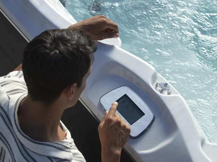 Man using touchscreen controls on PowerPro Swim Spa