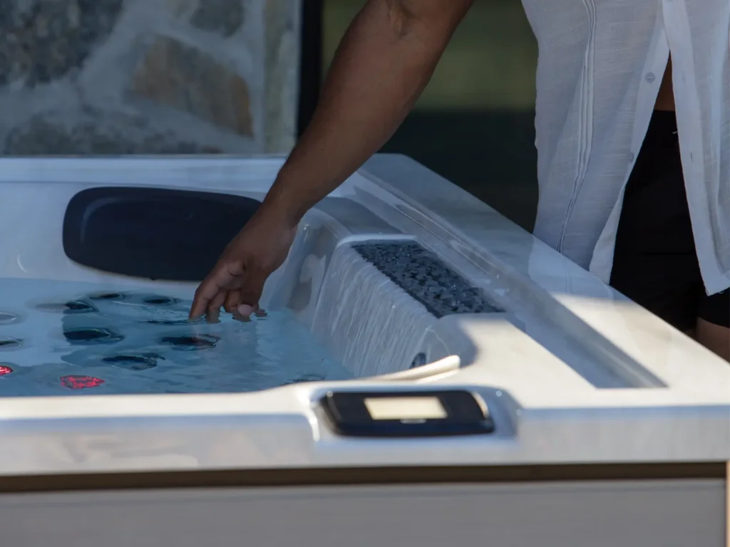 Man touching water in Jacuzzi J-LX hot tub